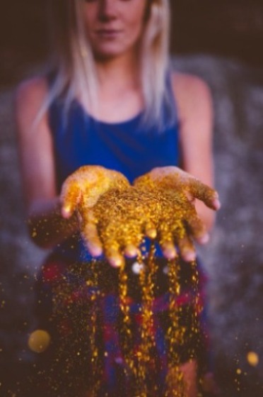 A woman standing with gold glitter