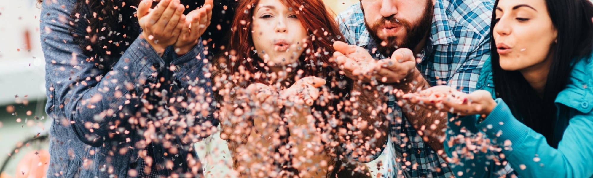 Team of millennials blowing glitter confetti